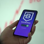Mão segurando um smartphone com a tela de uma carteira de criptomoedas baseada em blockchain