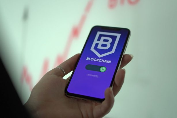 Mão segurando um smartphone com a tela de uma carteira de criptomoedas baseada em blockchain