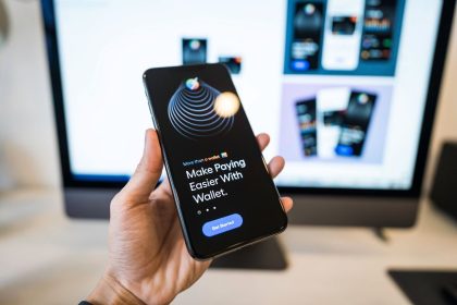 Mão segurando um smartphone com a interface de uma carteira digital na tela.